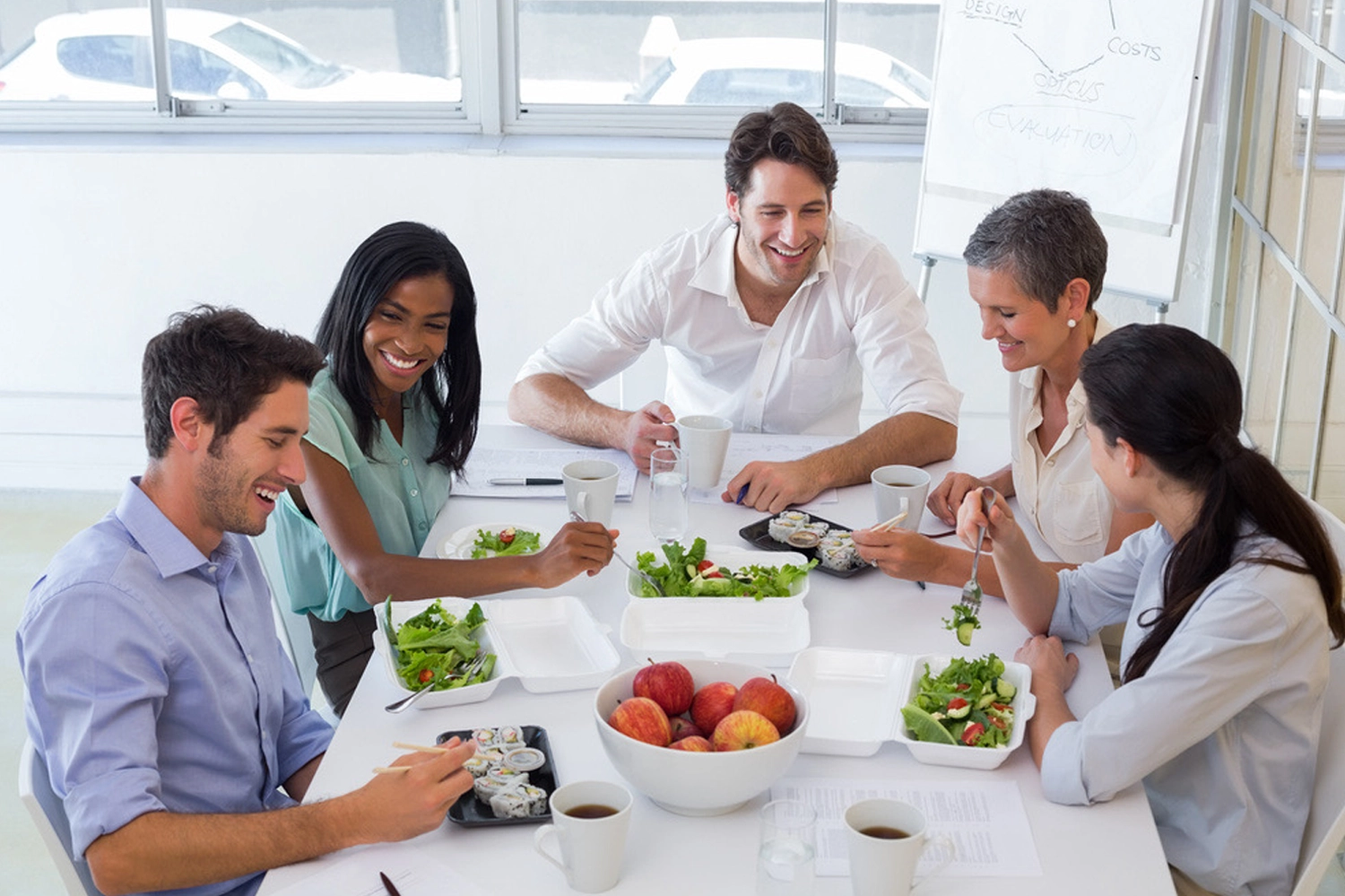 Happy employees socializing over lunch in a vibrant office cafeteria